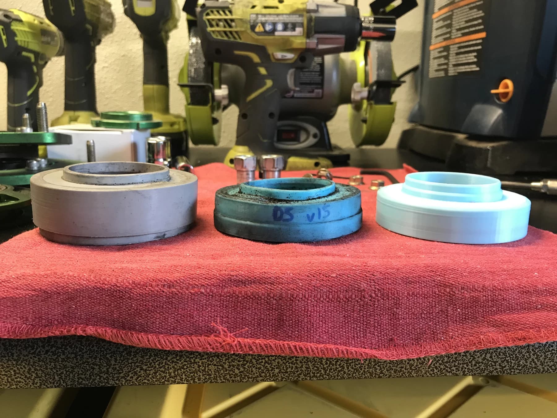 Three housing assemblies side by side on a red towel on the workbench.