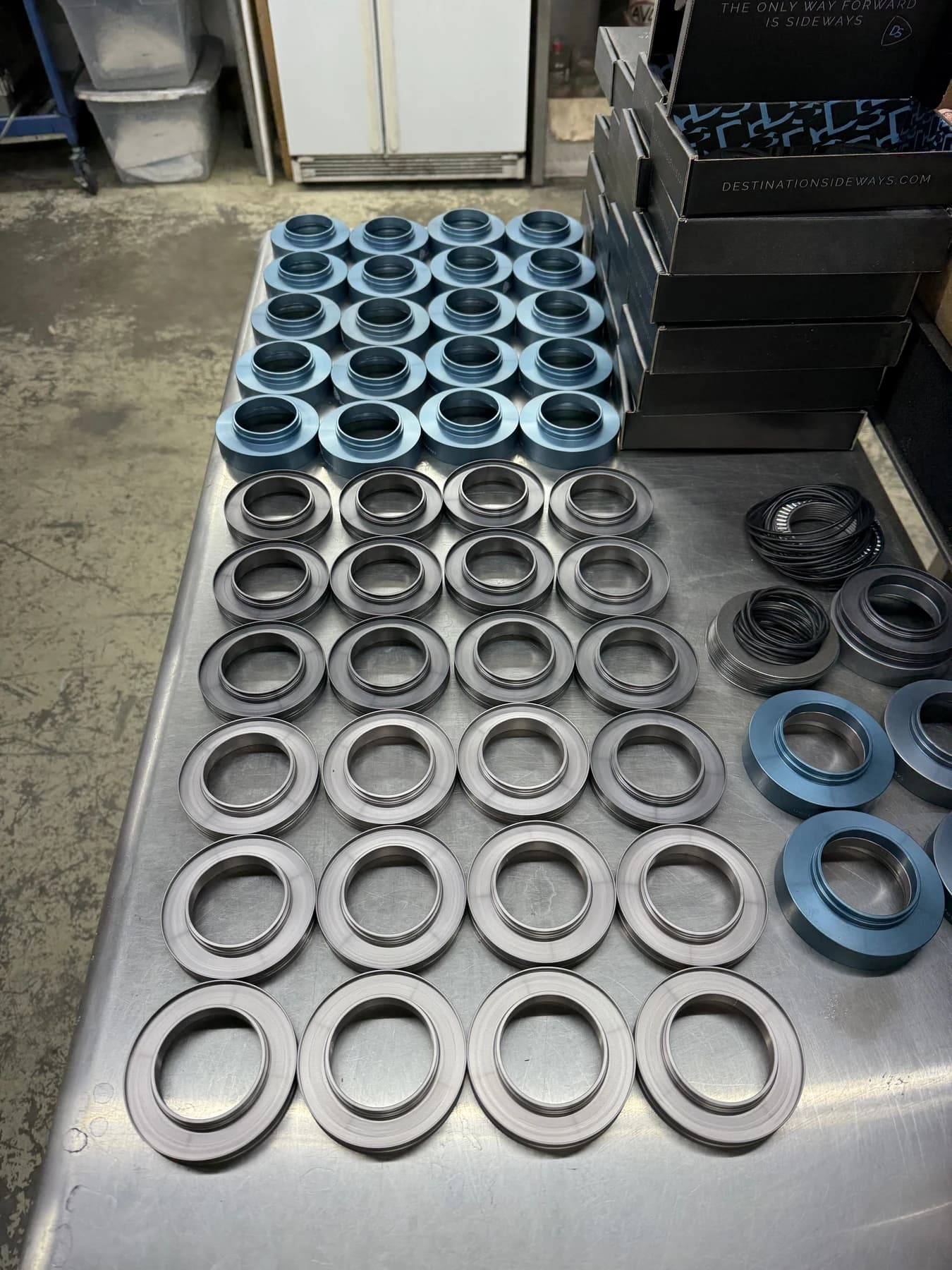 Blue and silver housings with black seals laid out on a workbench.